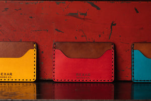 two pocket leather wallet with center divider shown in red, yellow, blue exteriors  with brown leather  interior