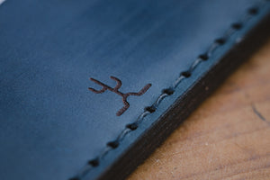 detail of cactus engraving on blue cordovan and brown leather two pocket slim wallet