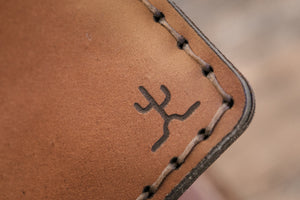detail of cactus engraving on Whiskey cordovan and brown leather six pocket bifold wallet