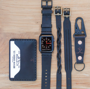 black cordovan leather exterior with black cow leather interior two card pocket slim wallet next to keychain and watch strap