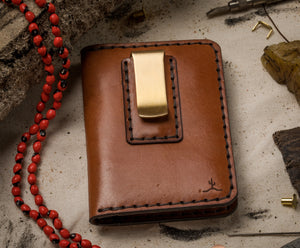 closed exterior view of brown leather four pocket folding wallet with brass money clip