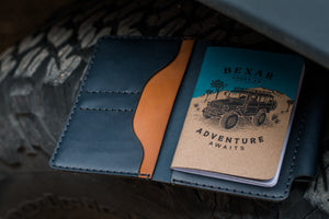 blue and brown leather notebook wallet with 4x4 journal book on an off road tire