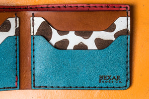 closeup interior view of multicolor four pocket bifold wallet with red, blue, yellow, and cowprint leather