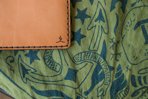 detail shot of laser engraved cactus logo on russet brown color leather wallet with four card pockets