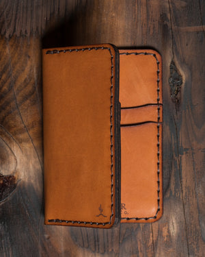 interior/exterior view of brown leather vertical wallet on top of wood block