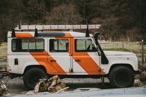 4x4 vehicle with orange and white painted stripes