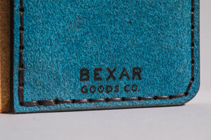 bexar goods branded on interior of multicolor four pocket vertical wallet with red, blue, yellow, and cowprint leather