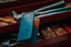 blue exterior and brown interior leather wallet with four card pockets in toolbox with leather tools