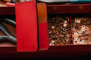 red exterior and brown interior leather wallet with four card pockets in toolbox with leather tools