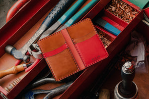 red exterior and brown interior leather wallet with four card pockets in toolbox with leather tools