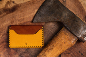 Yellow and brown slim wallet- two pocket with one center divider next to axe