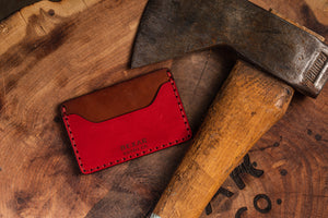 closeup detail of leather wallet with two pocket sleeves and one center divider next to axe
