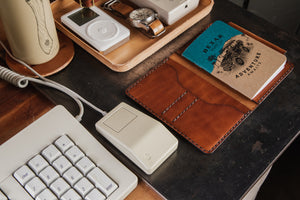 computer workstation overview of interior view of brown leather notebook wallet with card sleeves and passport sleeve