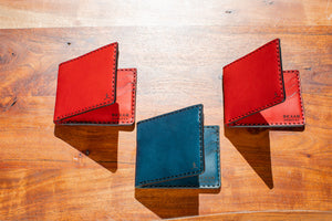 red and blue leather six pocket wallets shown open interior and exterior on wood block