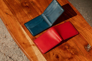 red and blue leather six pocket wallets shown open interior and exterior on wood block