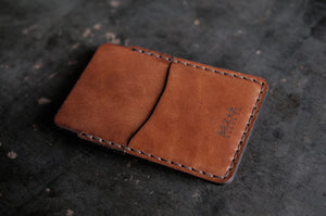 front view of two pocket simple brown leather wallet with brass money clip on exterior back