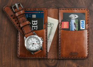 interior of green and brown leather four card vertical wallet next to analog watch