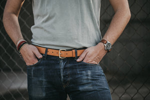 Adult male closeup of blue jeans and tan leather belt