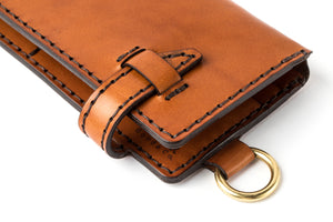 detail of leather closure on eight pocket long brown leather wallet with brass keychain lanyard