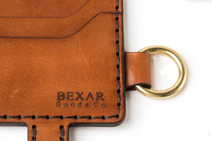detail of laser engraved bexar logo on eight pocket long brown leather wallet with brass keychain lanyard