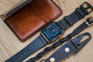 black cordovan leather exterior with brown leather interior four pocket vertical wallet next to watch strap and keychain