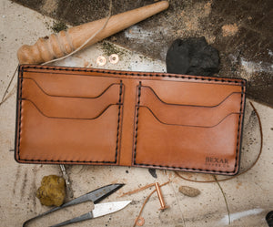 interior view of brown leather bifold 4 pocket wallet surrounded by hand tools