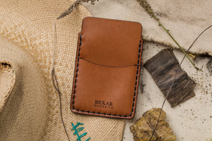 frontal view of two pocket simple brown leather wallet with brass money clip on exterior back