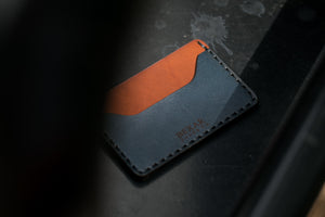 closeup profile view of blue and brown leather two pocket slim wallet