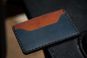 profile view of blue and brown leather two pocket slim wallet