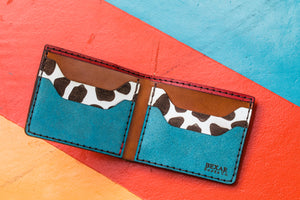 interior view of multicolor four pocket bifold wallet with red, blue, yellow, and cowprint leather
