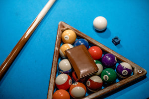 exterior view of brown leather vertical wallet on top of billiard balls