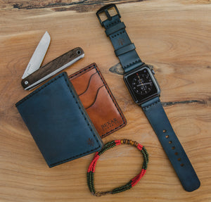 blue cordovan and brown leather four pocket bifold wallet next to matching watch strap