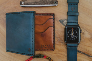 blue cordovan and brown leather four pocket bifold wallet next to matching watch strap