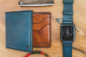 blue cordovan and brown leather six pocket bifold wallet next to matching watch strap