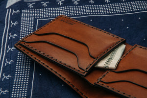 interior of brown four card pocket and two stash pockets with cash displayed on top of navy bandana