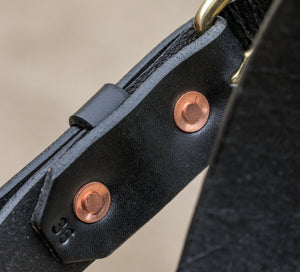 Backside of black leather belt hand hammered copper rivets