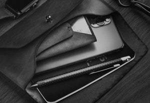 leather folding card wallet next to keychain and watch