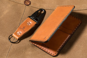 whiskey cordovan leather with brown interior four pocket vertical wallet next to keychain