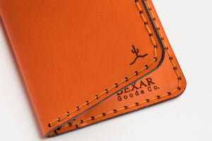 closeup of engraving on four pocket vertical orange leather wallet 