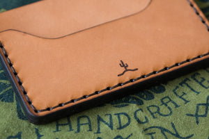 detail of laser engraved cactus logo on russet brown color leather slim wallet with two card pockets