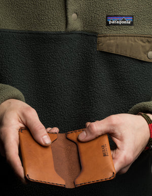 man holding  three card brown leather wallet
