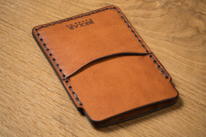 top view showing pockets on two pocket simple brown leather wallet with brass money clip on exterior back