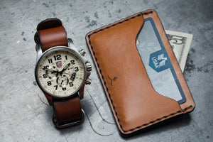 everyday carry overlay showing two pocket wallet next to analog watch with leather strap