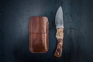  brown leather phone sleeve with card sleeve next to knife