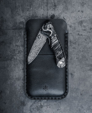 black leather phone sleeve with card pocket next to knife