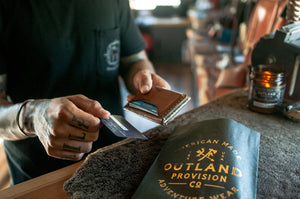 man holding three card brown leather wallet while paying with card