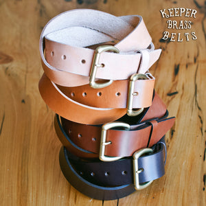 4 Belts stacked on top of each other showcasing color offerings. Black, Medium Brown, Tan, Raw Leather