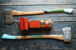 four pocket vertical orange leather wallet surrounded by two axes and similar wallet