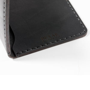 detail of laser engraved bexar logo on black leather passport wallet with two card pockets