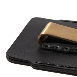 closeup of black leather card sleeve with outer sleeve wallet and brass money clip